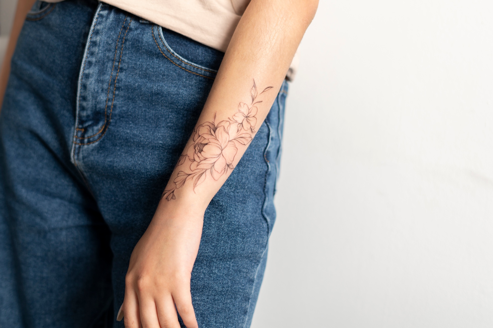 close up view of woman showing her finished flowers tattoo on her hand
