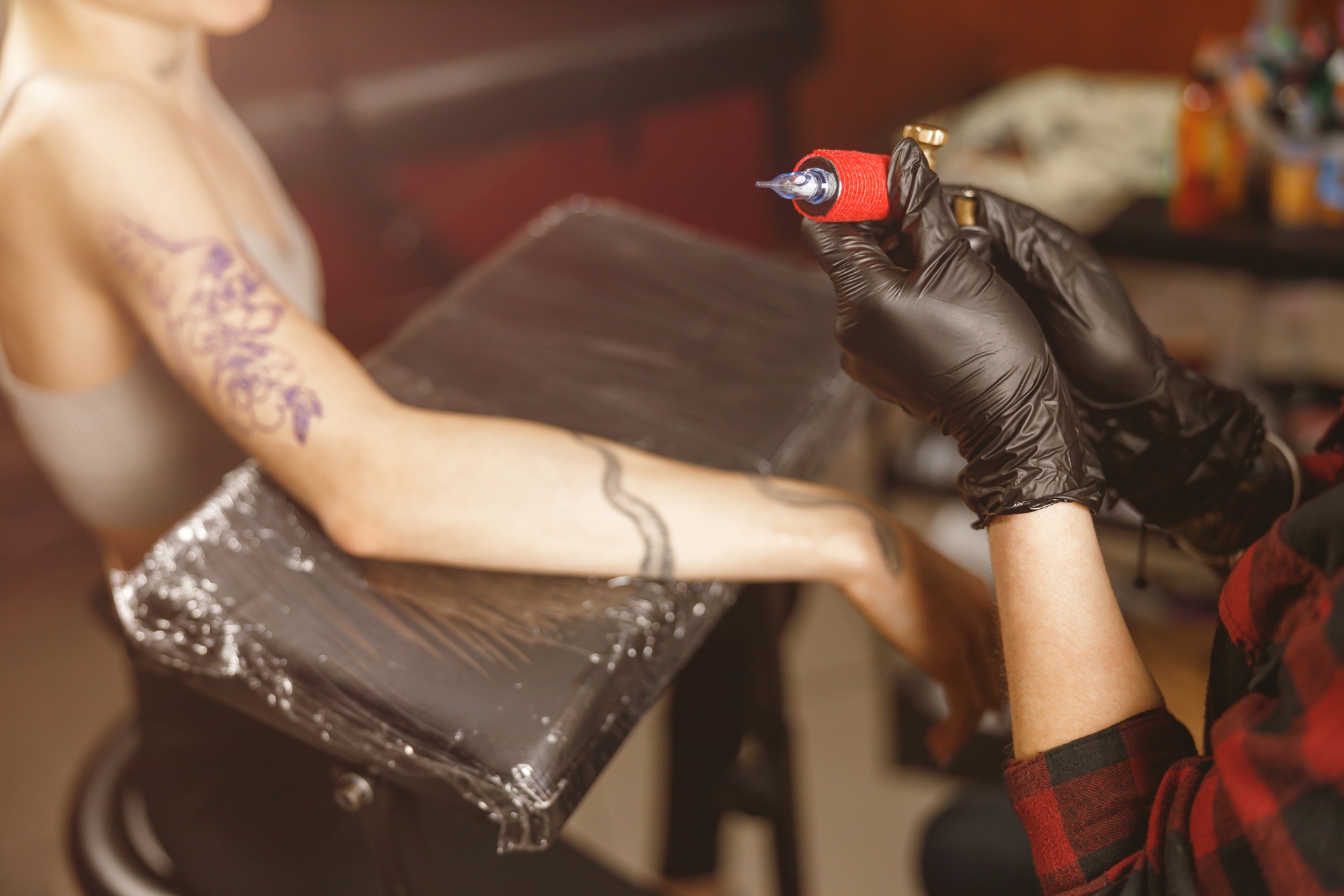 Tattoo artist holding tattoo machine in salon